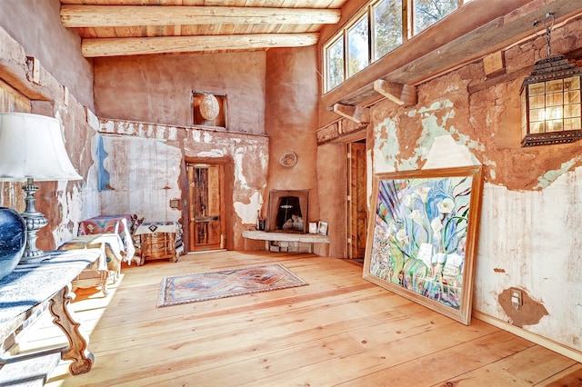 interior space featuring high vaulted ceiling, hardwood / wood-style flooring, and beamed ceiling