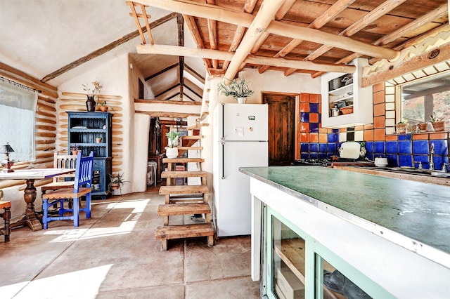 kitchen featuring concrete floors, lofted ceiling with beams, and white refrigerator