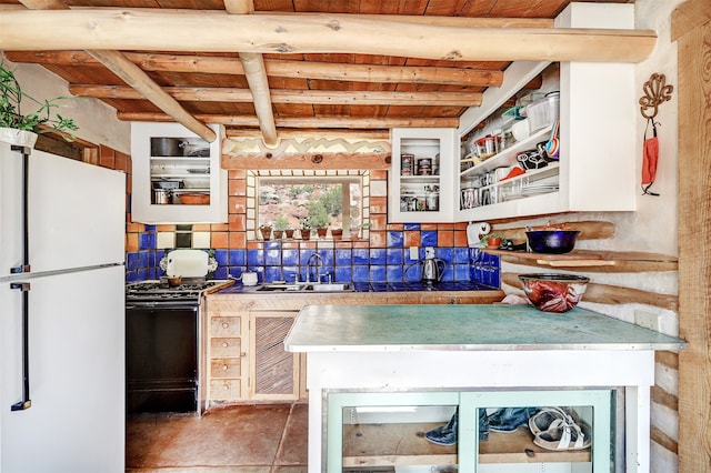 kitchen with tasteful backsplash, beamed ceiling, sink, black gas range oven, and white refrigerator