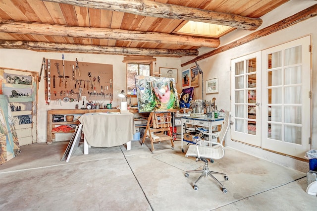 miscellaneous room with beamed ceiling, concrete flooring, a workshop area, and wooden ceiling