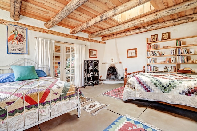 bedroom with beamed ceiling, wood ceiling, concrete floors, and a skylight