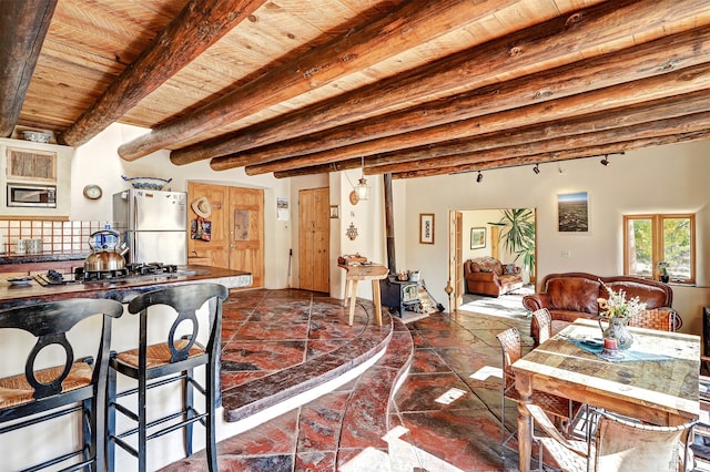 dining space with beamed ceiling and wooden ceiling