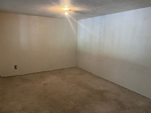 carpeted empty room featuring a textured ceiling