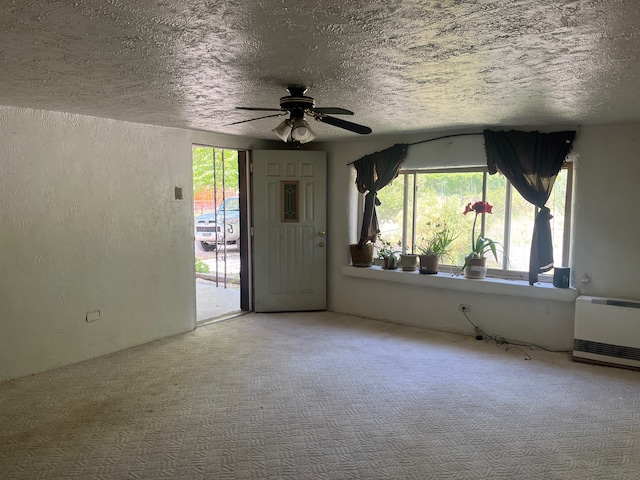 interior space with ceiling fan and a textured ceiling