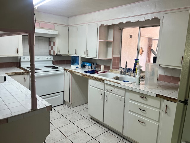 kitchen with white electric range oven, sink, tile counters, and tasteful backsplash