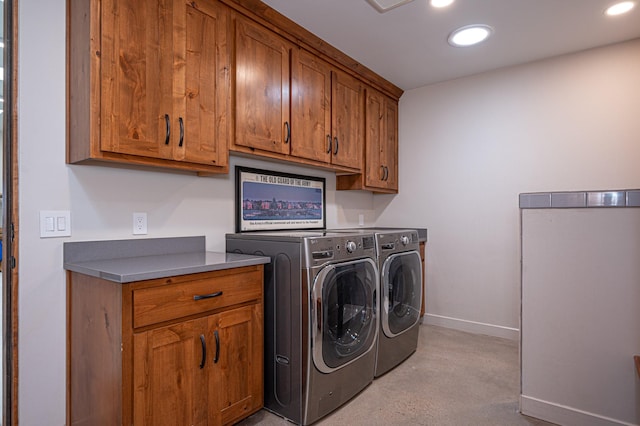 washroom with washer and dryer and cabinets