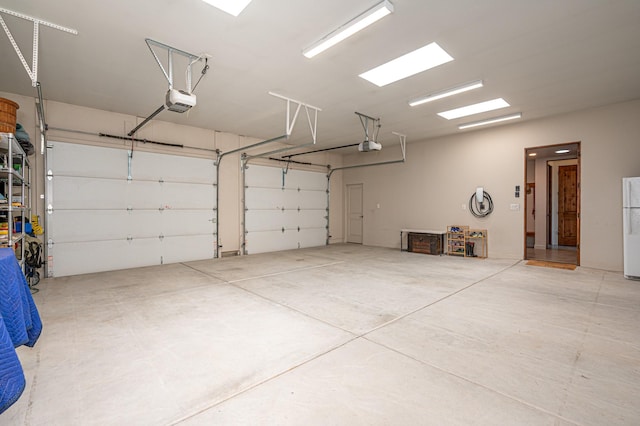 garage with white refrigerator and a garage door opener