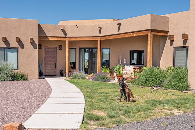 entrance to property featuring a lawn