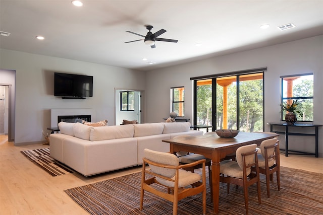 dining space with ceiling fan and light hardwood / wood-style floors