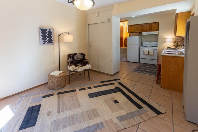 kitchen with white appliances, sink, and light tile patterned floors