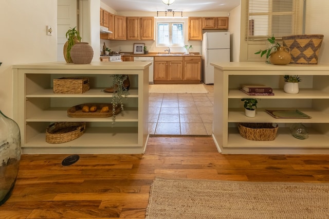 kitchen featuring sink, light hardwood / wood-style floors, and white appliances