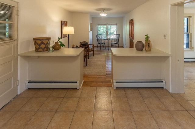 hall with baseboard heating and light tile patterned floors