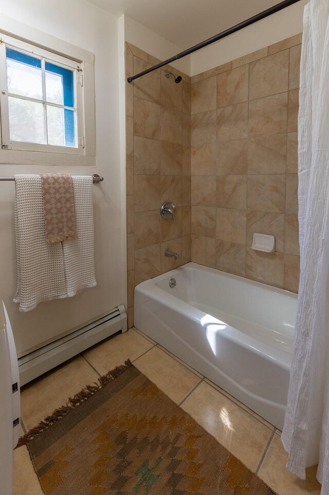 clothes washing area featuring light tile patterned floors, baseboard heating, and stacked washer / drying machine