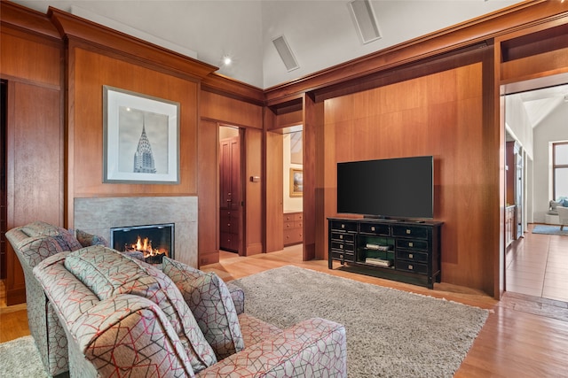 living room featuring light hardwood / wood-style flooring, a fireplace, and a high ceiling