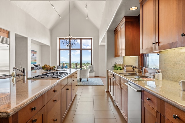 kitchen with stainless steel appliances, decorative light fixtures, light stone countertops, and light tile patterned floors