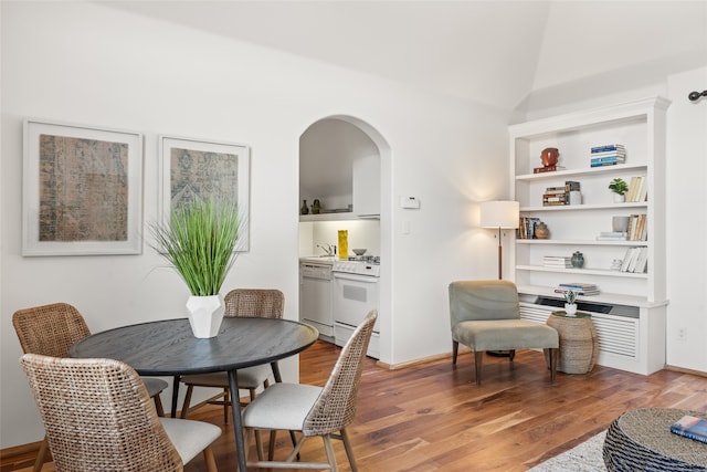 dining space with hardwood / wood-style flooring, sink, and built in shelves