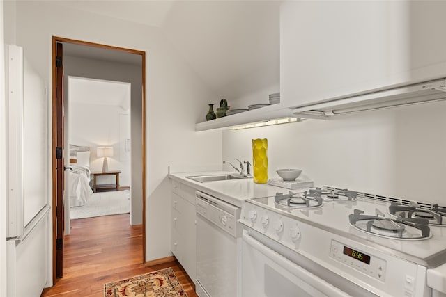 kitchen featuring white appliances, lofted ceiling, sink, and light hardwood / wood-style flooring