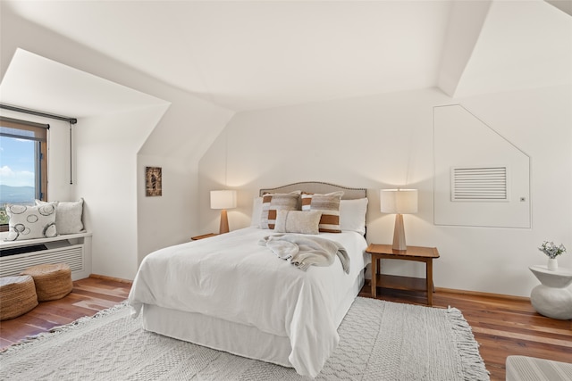 bedroom with vaulted ceiling and wood-type flooring