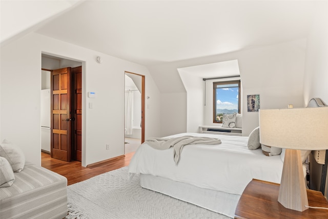 bedroom featuring vaulted ceiling and light hardwood / wood-style flooring