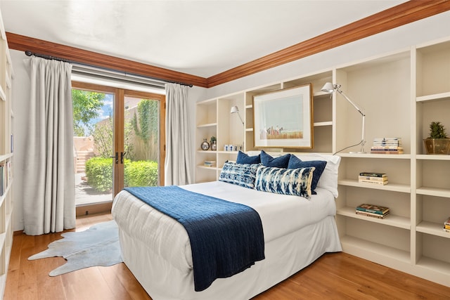 bedroom featuring hardwood / wood-style flooring, ornamental molding, french doors, and access to outside