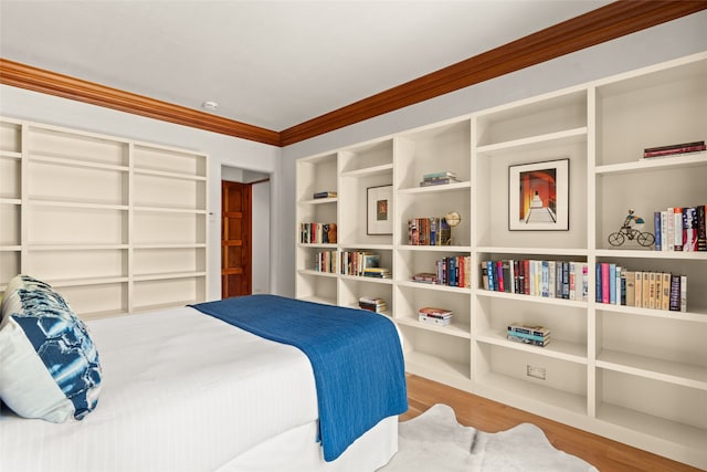 bedroom featuring wood-type flooring and ornamental molding