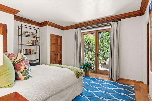 bedroom with crown molding, access to outside, and light hardwood / wood-style floors