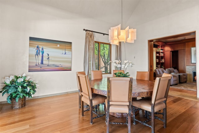 dining space with hardwood / wood-style flooring and high vaulted ceiling