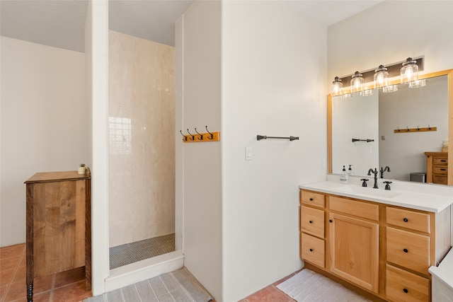 bathroom with tile patterned floors, vanity, and walk in shower