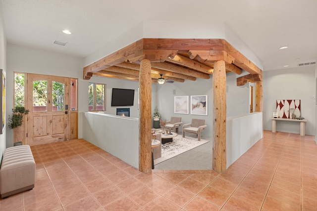 tiled living room featuring beam ceiling and ceiling fan