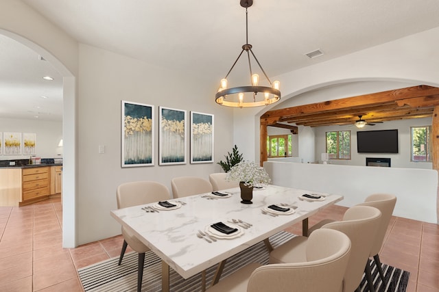 tiled dining room featuring ceiling fan with notable chandelier and a healthy amount of sunlight