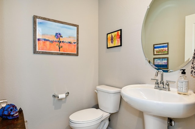 half bathroom with toilet and a sink