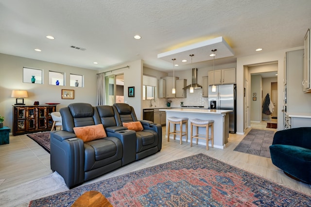 living room with a textured ceiling and light wood-type flooring