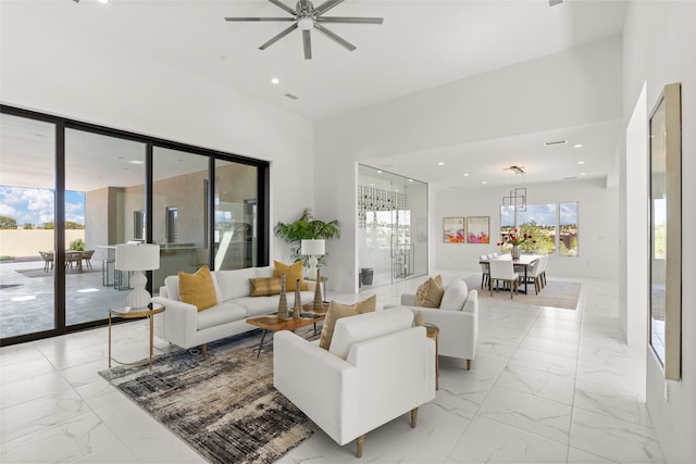 living area featuring a ceiling fan, recessed lighting, and marble finish floor