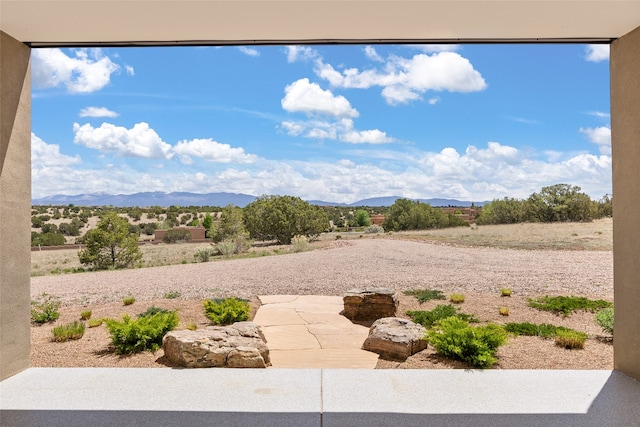 view of yard featuring a patio and a mountain view