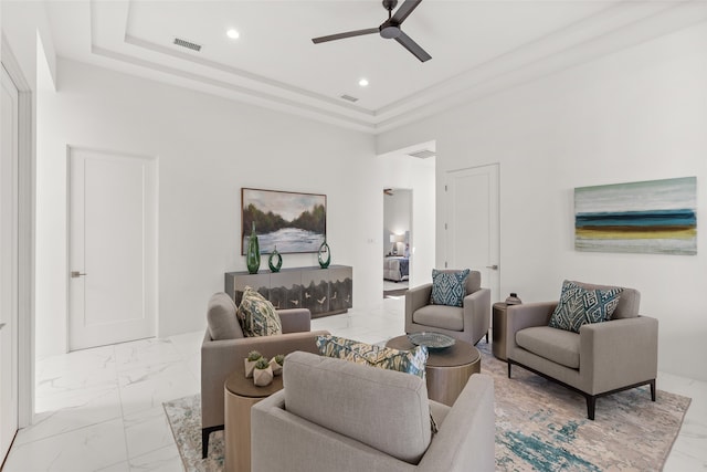 living room with a tray ceiling, ceiling fan, light tile patterned flooring, and a towering ceiling