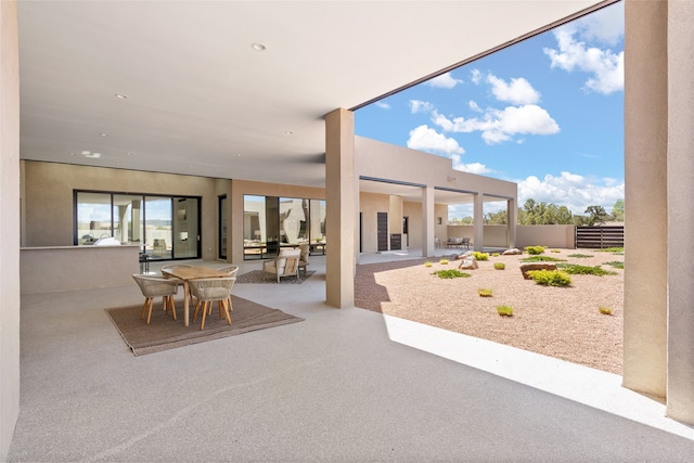 view of patio featuring outdoor dining area and fence