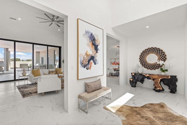 hallway with recessed lighting, a high ceiling, and marble finish floor