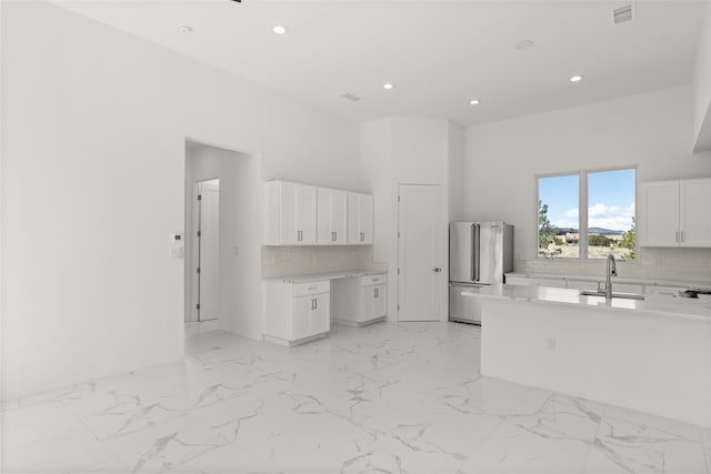 kitchen with a sink, visible vents, marble finish floor, and freestanding refrigerator