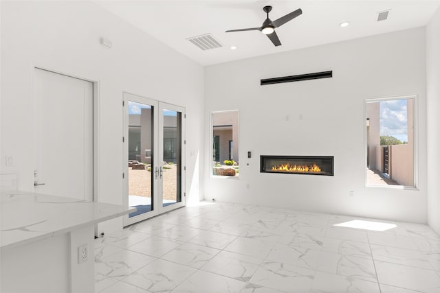 unfurnished living room featuring french doors, light tile patterned floors, and ceiling fan