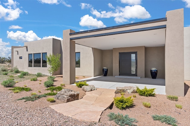 rear view of property featuring stucco siding