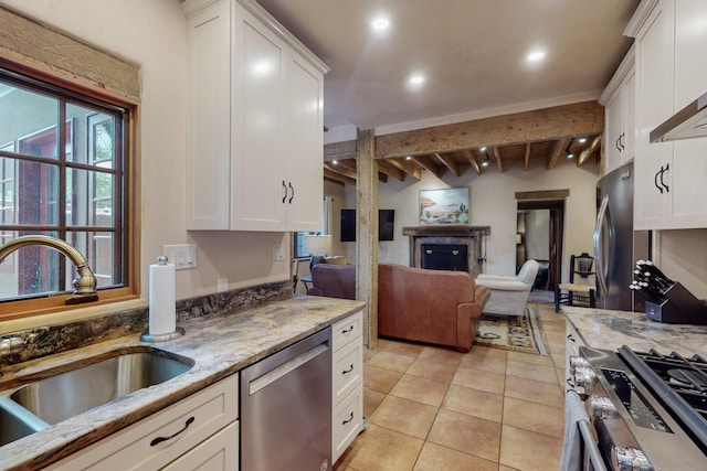 kitchen featuring white cabinets, sink, beamed ceiling, and stainless steel appliances