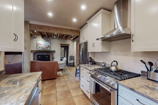 kitchen featuring beam ceiling, white cabinetry, wall chimney exhaust hood, high end stainless steel range oven, and light stone counters