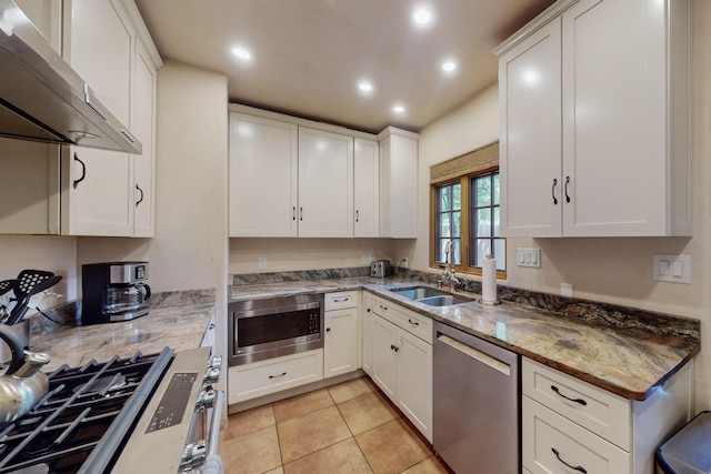 kitchen featuring white cabinets, light stone countertops, stainless steel appliances, and extractor fan