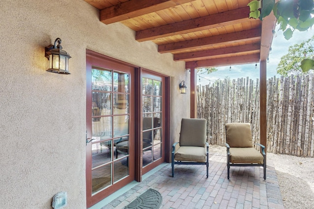 sunroom featuring beamed ceiling and wood ceiling