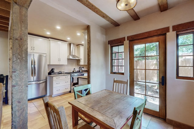 tiled dining area featuring beam ceiling