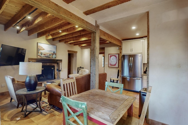 dining space with a fireplace, beamed ceiling, and light tile patterned floors