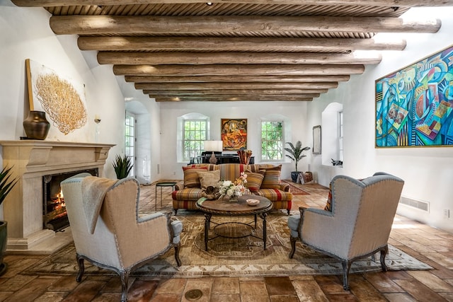 living room featuring beam ceiling and a high end fireplace