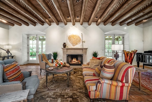 living room with beam ceiling, french doors, a wealth of natural light, and wooden ceiling