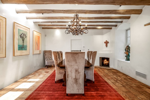 dining area with beamed ceiling and a notable chandelier