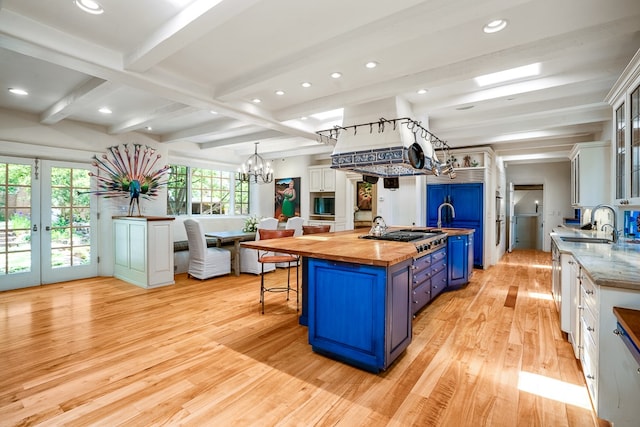 kitchen featuring wooden counters, light hardwood / wood-style floors, a center island, and blue cabinets